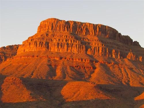 The mesa above the ranch lit orange at golden hour